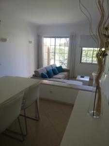 a living room with a couch with blue pillows at Villa V2 V in Olhos de Água