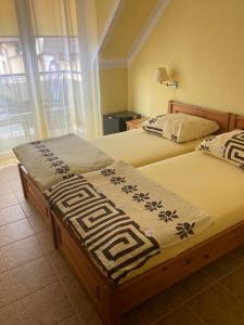 2 camas individuales en una habitación con ventana en Pod Delfinem Rewal, en Rewal