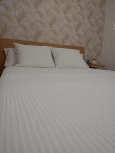 a white bed with white sheets and pillows at La Lunita in Valverde