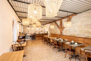 a restaurant with wooden tables and chairs and chandeliers at La Ferme du Lignon in Geneva