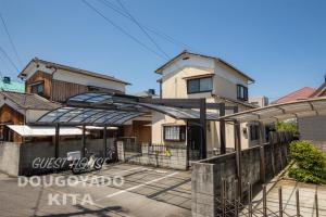 松山的住宿－GUEST HOUSE DOUGOYADO KITA - Vacation STAY 14923，前面有围栏的房子