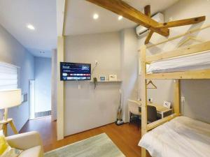 a bedroom with a bunk bed and a tv on the wall at 日向サーフキャンプ101 in Hyuga +20 photos