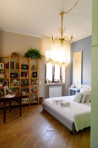 1 dormitorio con cama, mesa y lámpara de araña en Mimma bed&flavour en Narni