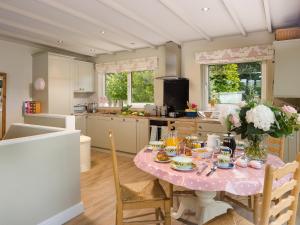 a kitchen with a table with flowers on it at Mere View in Windermere