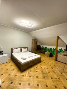 a bedroom with a large bed and wooden floors at Metekhi View Hotel in Tbilisi City
