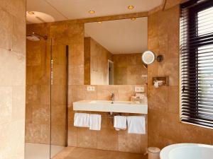 een badkamer met een wastafel en een spiegel bij Gatsby Hotel - Adults Only - Small Luxury Hotel - by F-Hotels in Blankenberge