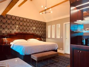 a bedroom with a large bed and a kitchen at Gatsby Hotel - Adults Only - Restaurant - Small Luxury Hotel by F-Hotels in Blankenberge