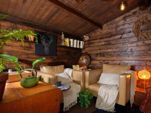 a living room with a couch and chairs in a log wall at La Cabane de l’Explorateur in Cholet