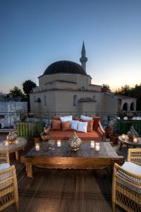 a patio with a couch and tables on a roof at DECAN Concept Boutique Estate in Rhodes Town