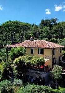 une maison jaune avec un toit en tuiles rouges dans l'établissement Villa Schindler, à Manerba del Garda