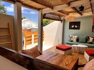a living room with a couch and a table at Kaz'Ban, 2ème ligne, 40 m du lagon in Saint-Leu