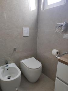 uma casa de banho com um WC branco e um lavatório. em B&B Spiaggia Le Dune em Margherita di Savoia