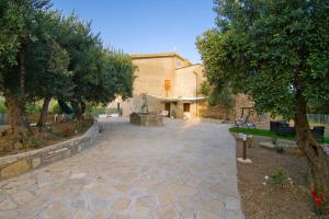 a stone courtyard with trees and a building at Villa Rosa Francesca in Acciaroli