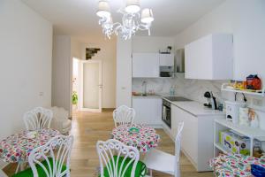 a kitchen with white cabinets and white chairs at Villa Rosa Francesca in Acciaroli