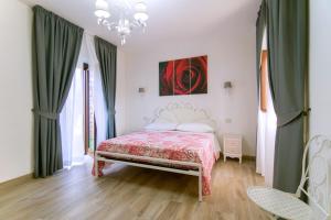 a bedroom with a bed and green curtains and a chandelier at Villa Rosa Francesca in Acciaroli