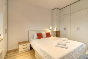 a bedroom with a large white bed with towels on it at Homie Studio Apartment - Private Parking - Self Check-In in Bucharest