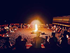 ワディ・ラムにあるベドウィン ライフスタイル キャンプの火壇に座る群衆