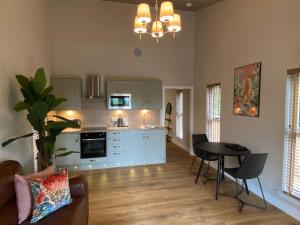 a kitchen and living room with a table and chairs at Conker Lodge with Hot Tub in Cupar