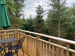 a balcony with a table and chairs on a wooden deck at Conker Lodge with Hot Tub in Cupar