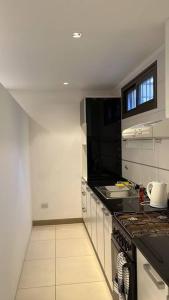 een keuken met een fornuis en een aanrecht bij Departamento Cabernet, 4 Huésped by Inside in Godoy Cruz