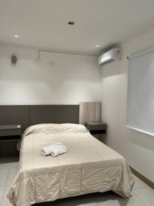een slaapkamer met een bed met een witte handdoek erop bij Departamento Cabernet, 4 Huésped by Inside in Godoy Cruz