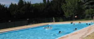 a group of people swimming in a swimming pool at Aux Couleurs Miel in Montolieu +12 photos