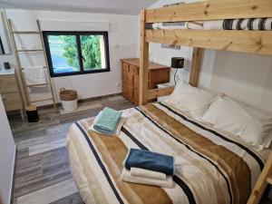 a bedroom with a bunk bed with towels on it at Gite de charme La Martinelle in La Bégude-de-Mazenc