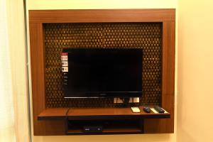 a flat screen tv in a wooden entertainment center at Hotel Plaza Inn, Ajmer in Ajmer