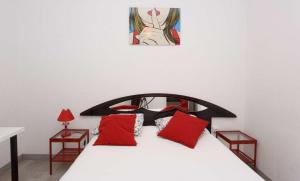 sypialnia z białym łóżkiem z czerwonymi poduszkami w obiekcie Desing Puerta del Sol 6 w Madrycie