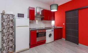 a kitchen with red cabinets and a white refrigerator at Desing Puerta del Sol 6 in Madrid