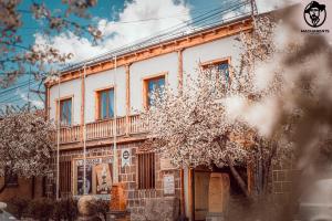an old white building with a tree in front of it at Machanents Art Hotel in Vagharshapat