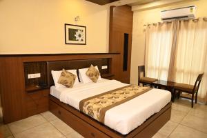 1 Schlafzimmer mit einem Bett und einem Schreibtisch sowie einem Bett der Marke sidx sidx sidx. in der Unterkunft Hotel Plaza Inn, Ajmer in Ajmer