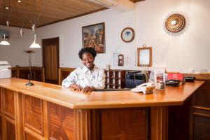 a woman sitting at a counter in an office at Esther's Hotel in Accra