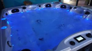 una bañera de hidromasaje con luces azules. en Villa Argonne, en Ouville-la-Rivière