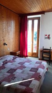 a bedroom with a bed and a large window at HOTEL Le TOURISME in Passy