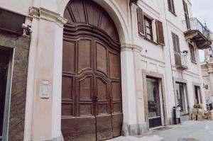 una gran puerta de madera en el lateral de un edificio en [Historic Center] Charming Apartment Free Wi-Fi en Savigliano