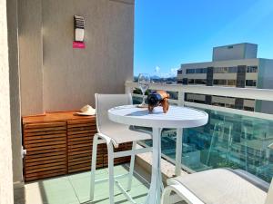 un tavolo bianco e sedie su un balcone con finestra di FLAT exclusivo no Hotel RAMADA Macaé, Smartv, Wifi 512Mbps, piscina e Garagem a Macaé