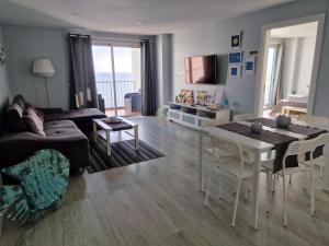 a living room with a couch and a table with chairs at Crepúsculo in Puerto de la Madera