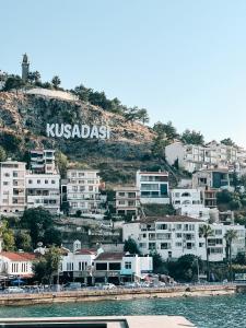 a bunch of houses on a hill next to the water at Seaside Serenity.Kusadasi,Turkey in Kusadası