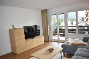 ein Wohnzimmer mit einem Sofa und einem TV in der Unterkunft Rhodania A 3003 Kl in Lenzerheide