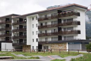 an apartment building with people on balconies at Rhodania A 3003 Kl in Lenzerheide