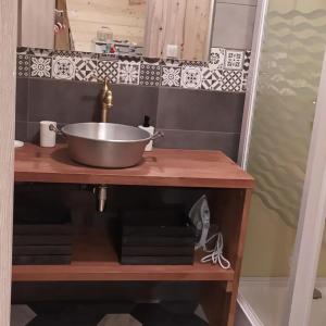 Charmant Gite 4 Places dans le Jura في Marigny: حوض الحمام مع وعاء على منضدة خشبية