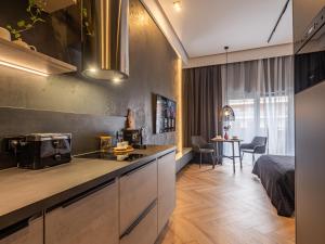 a kitchen and living room with a bed in a room at Loft House Apartments in Wrocław