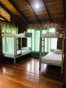 2 literas en una habitación con suelo de madera en Ávita Lodge en Quesada