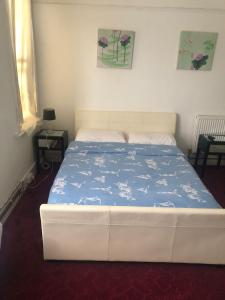 a bedroom with a bed with a blue comforter at Alysguesthub in London