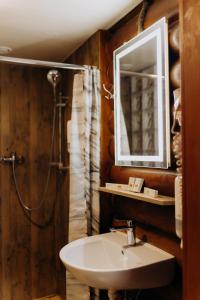 een badkamer met een wastafel, een douche en een spiegel bij Arta City Hotel in Yavoriv