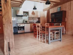 a kitchen with a wooden table and chairs at Charmant Gite 6 Places Secteur Jura in Marigny