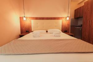 ELYSIUM - villa majken في أولمبياكي أكتي: غرفة نوم بسرير كبير عليها منشفتين