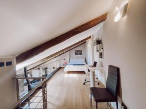 un dormitorio en el ático con una cama y un escritorio en una habitación en [Historic Center] Charming Apartment Free Wi-Fi en Savigliano