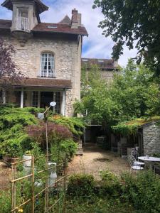 stary dom z ogrodem przed nim w obiekcie Atelier chez Marie w mieście Carnetin